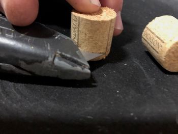 Put the razor knife flat to your table surface and hold it there firmly. Then put your cork's uncut side down to the table surface, with the cork up to the knife blade. Once in position, carefully cut a groove in the cork by rotating it around the blade. You shouldn't need to move the blade -- just keep it steady and carefully rotate the cork to put a groove in it. If you're using a champagne cork you may want to skip this step and just cut down to the mushroom-y end of the cork in the next step.