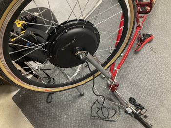 The fork drop-outs had to be filed slightly to fit the oversize axle on the ebike motor. I had also hoped to run the wiring up through the tubular fork, but couldn't manage to fish it through at the fork crown. So zip ties came to the rescue. You can also see the e-bike kit throttle and wiring, right by the original 3-speed shifter.