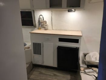 A lot of things were being test-fit here, particularly the new countertop, a new bar-sized faucet and the backsplash. You can also see the new electrical outlet (complete with ground fault protection and two USB ports) and over to the right, the new sink waiting to go in. Both the sink and faucet were bar-sized because the scale worked better for the little camper. We decided to skip the propane stove and either cook outside or with a hotplate.