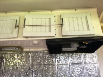 There are cabinets above the sink/kitchenette area. The doors, light fixtures and backsplash were all in terrible condition.