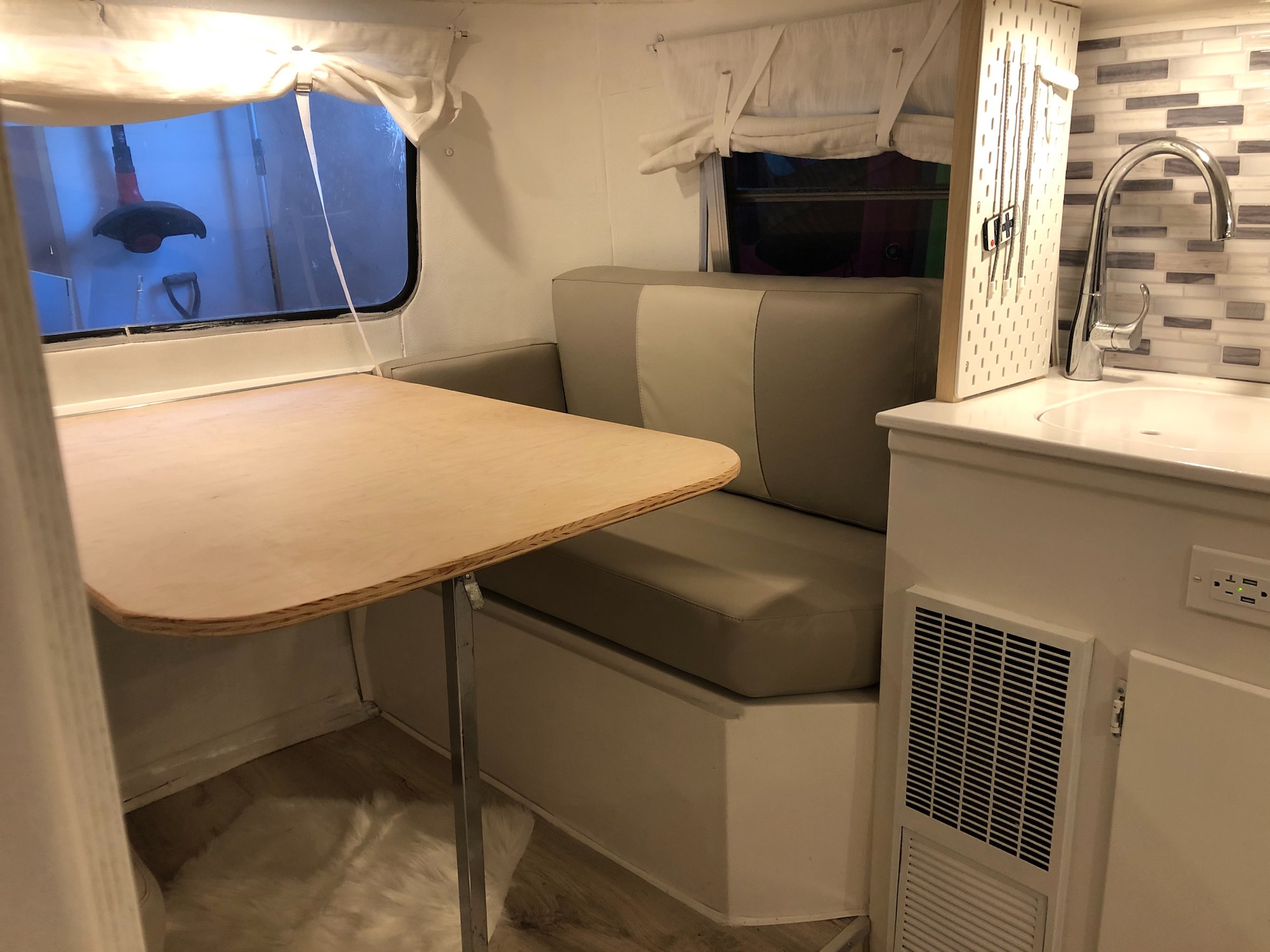 I don't have an industrial sewing machine or any real upholstery skills, so I figured it was smart to farm out the actual upholstery work. We had the cushions covered in a nice high-quality marine vinyl in a sort of two-tone gray/beige color.  We deliberately kept the colors very neutral and cold. The camper is so small that even a single pillow introduces a lot of color. I made the dinette table, too. Then later I made another one, 'cause I didn't like this one.